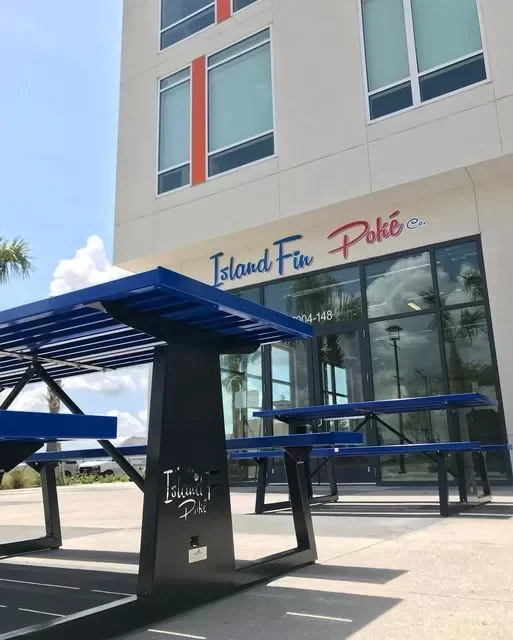 Island Fin Poké storefront — flagship location with branded picnic tables